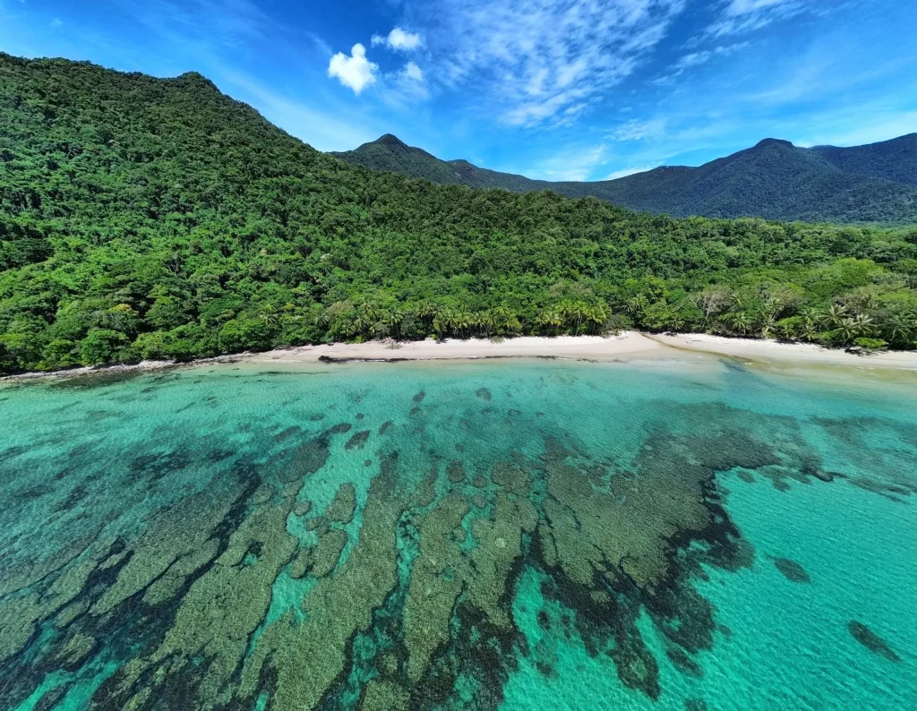 cape-tribulation-fringing-reef-bay-aerial Fringing reef in the shallows of a Cape Tribulation bay, forested peaks rising behind the beach